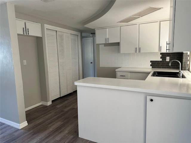 kitchen featuring white cabinetry, sink, decorative backsplash, and kitchen peninsula