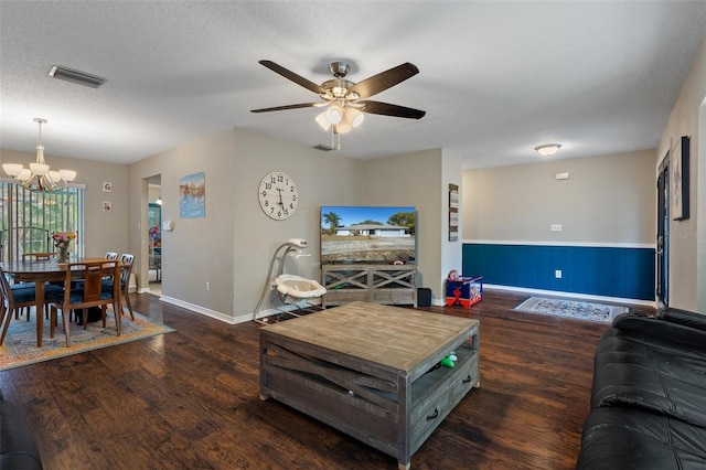 living room featuring ceiling fan with notable chandelier, a textured ceiling, and dark hardwood / wood-style flooring