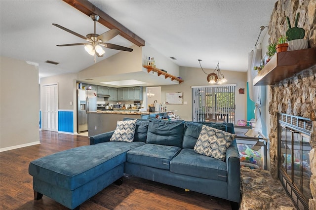 living room featuring lofted ceiling with beams, dark wood-type flooring, a fireplace, and a textured ceiling