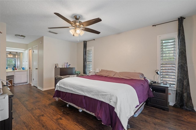 bedroom with ceiling fan, dark hardwood / wood-style flooring, multiple windows, and a textured ceiling