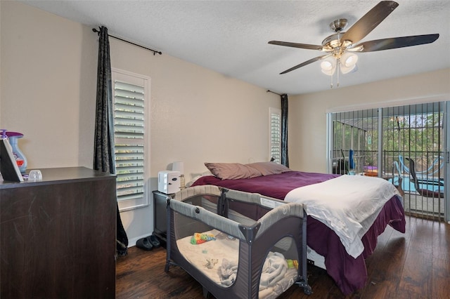 bedroom featuring dark hardwood / wood-style flooring, ceiling fan, and a textured ceiling