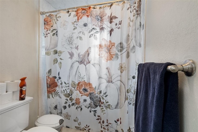 bathroom featuring toilet and walk in shower