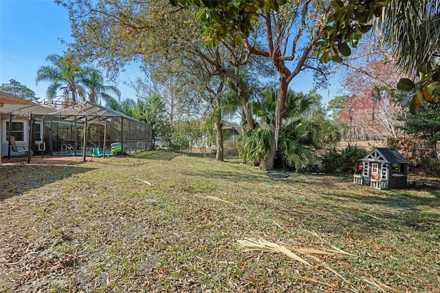 view of yard featuring a lanai and a storage shed