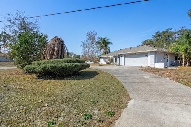 view of front of house featuring a garage, a front yard, and cooling unit