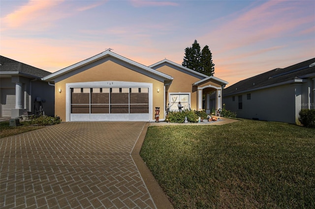 view of front of house with a garage and a lawn