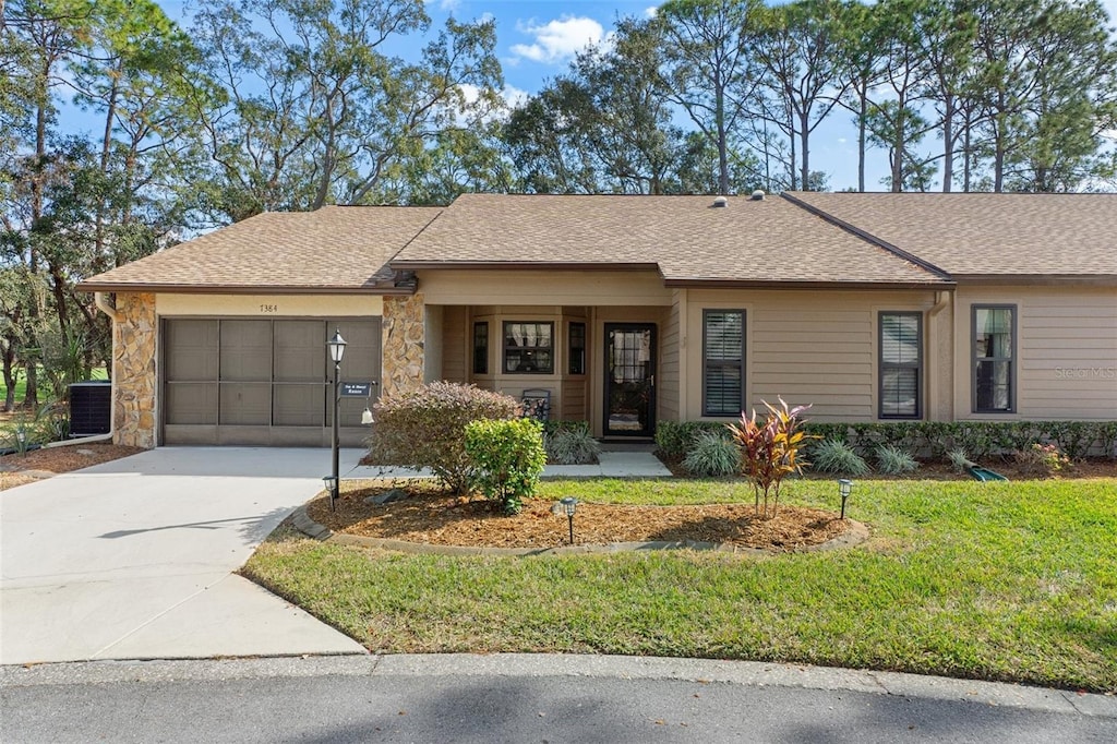 ranch-style home with a garage and a front lawn