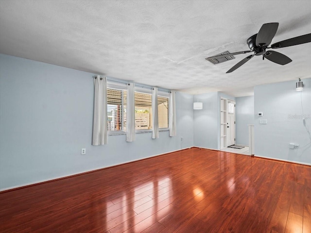 spare room with ceiling fan, wood-type flooring, and a textured ceiling