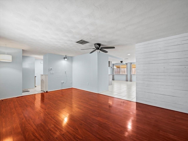 empty room featuring ceiling fan, a textured ceiling, and light hardwood / wood-style floors