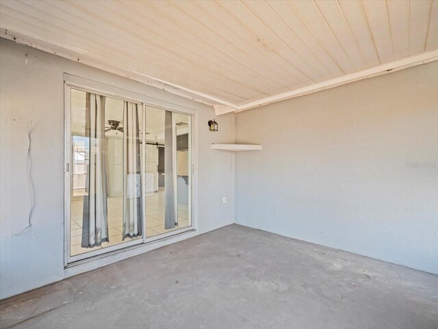 empty room featuring concrete flooring and wooden ceiling