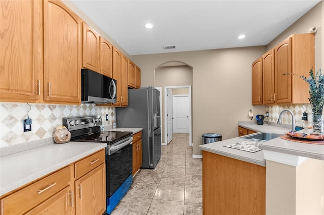 kitchen featuring appliances with stainless steel finishes, sink, light tile patterned floors, and backsplash