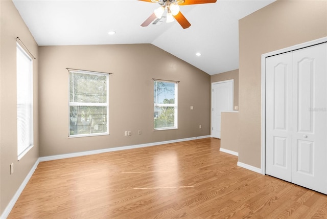 unfurnished bedroom featuring ceiling fan, lofted ceiling, light hardwood / wood-style floors, and a closet