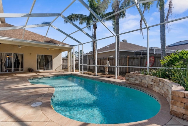 view of swimming pool with a patio, ceiling fan, and glass enclosure