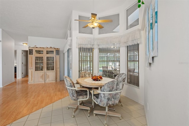 tiled dining space featuring ceiling fan