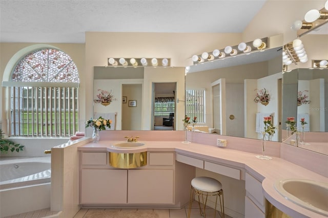 bathroom with vanity, tile patterned floors, tiled bath, and a textured ceiling