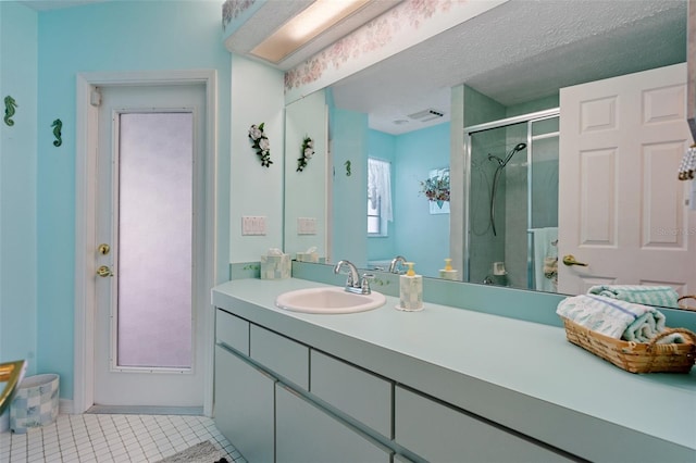 bathroom featuring vanity, a shower with shower door, tile patterned floors, and a textured ceiling