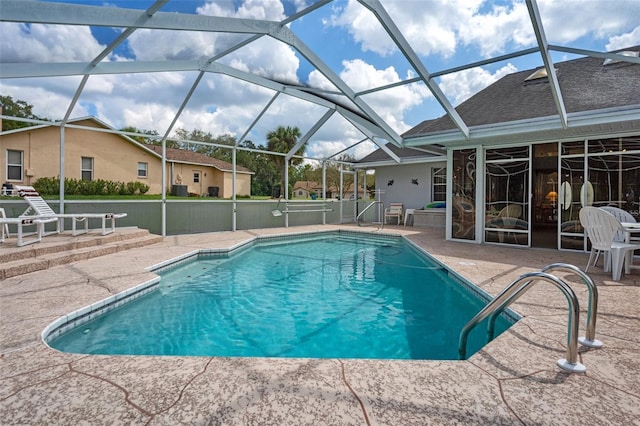 view of swimming pool with a patio area and glass enclosure