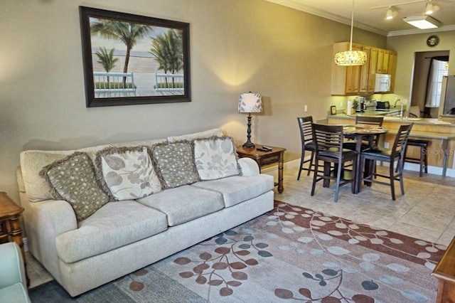 living room with light tile patterned floors, crown molding, and sink