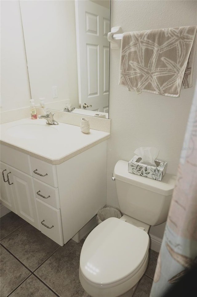 bathroom with vanity, toilet, and tile patterned flooring