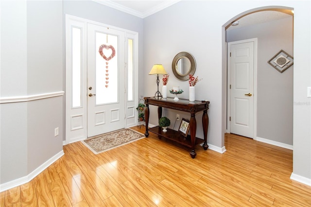 entrance foyer featuring crown molding and light wood-type flooring