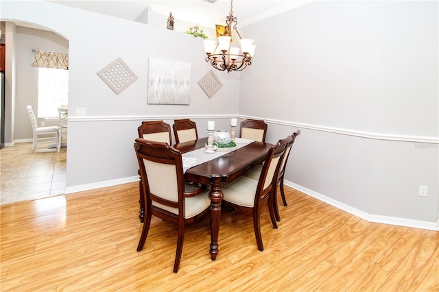 dining space featuring an inviting chandelier, crown molding, and light wood-type flooring