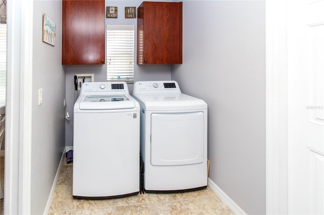 laundry room with washer and dryer, light tile patterned floors, and cabinets