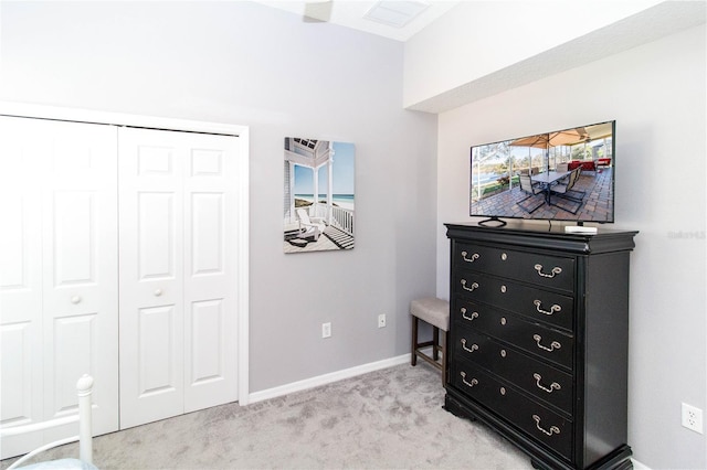 bedroom with light carpet and a closet