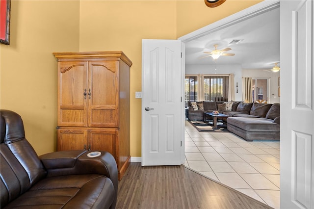 living room with light hardwood / wood-style flooring and ceiling fan