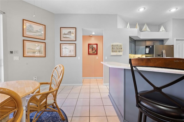 kitchen with gray cabinetry, stainless steel fridge with ice dispenser, and light tile patterned flooring