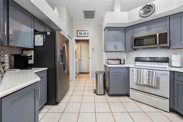 kitchen with gray cabinets, stainless steel appliances, and light tile patterned flooring