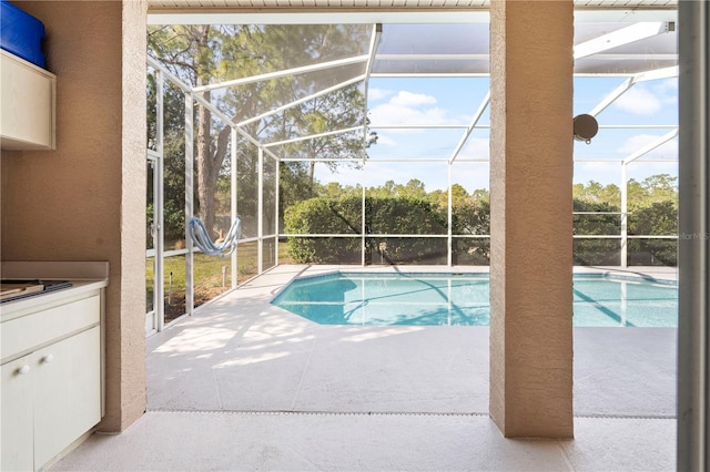 view of pool featuring glass enclosure and a patio area