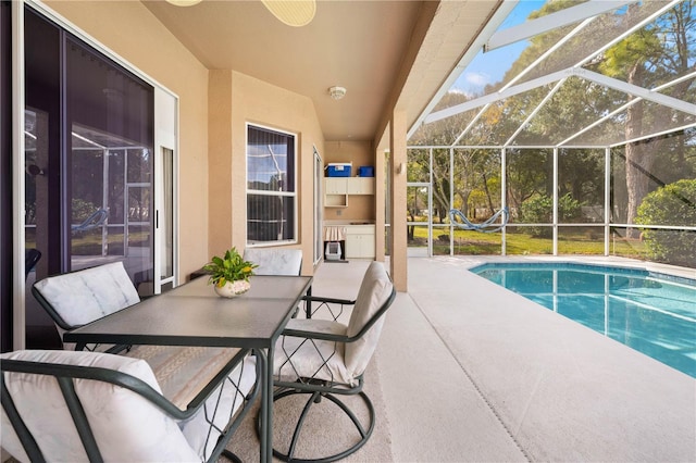 view of swimming pool featuring a lanai, ceiling fan, and a patio area