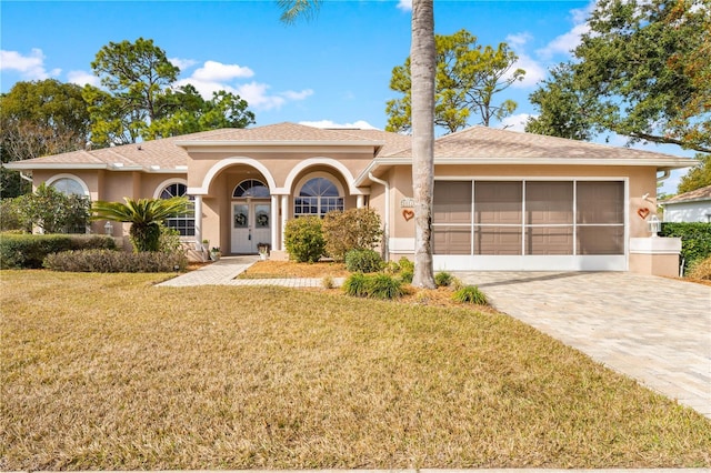 view of front of home with a garage, a front yard, and french doors