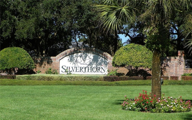 community / neighborhood sign featuring a yard