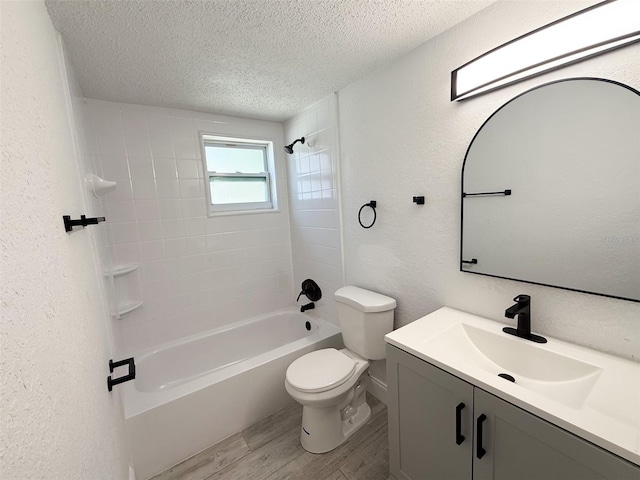 full bathroom featuring hardwood / wood-style floors, vanity, a textured ceiling, toilet, and tiled shower / bath