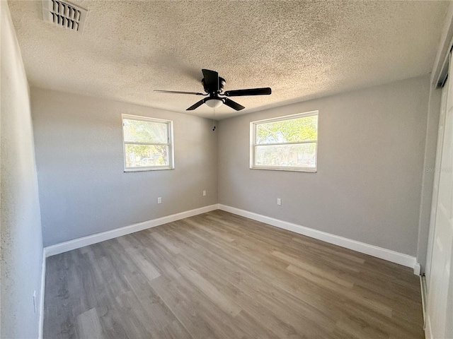 spare room with hardwood / wood-style floors, a textured ceiling, and ceiling fan