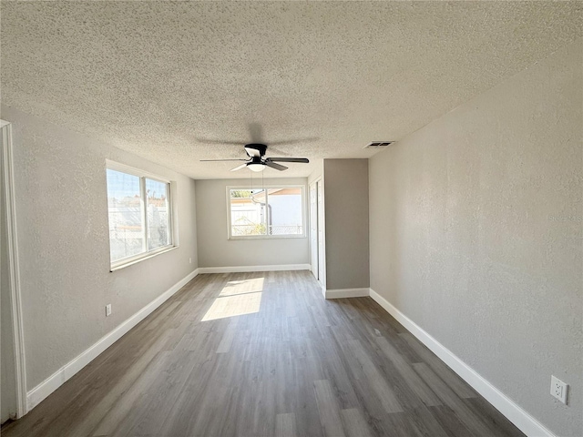 unfurnished room with hardwood / wood-style flooring, ceiling fan, and a textured ceiling