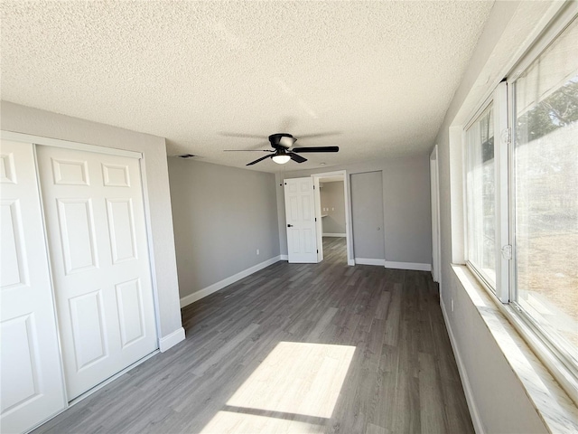 unfurnished bedroom featuring hardwood / wood-style flooring, ceiling fan, a textured ceiling, and a closet