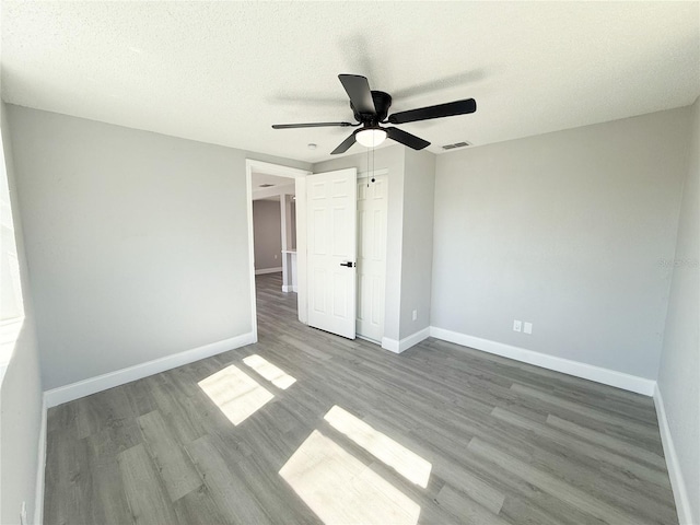 unfurnished bedroom with ceiling fan, light hardwood / wood-style flooring, and a textured ceiling