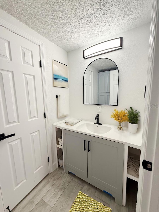 bathroom featuring hardwood / wood-style flooring, vanity, and a textured ceiling