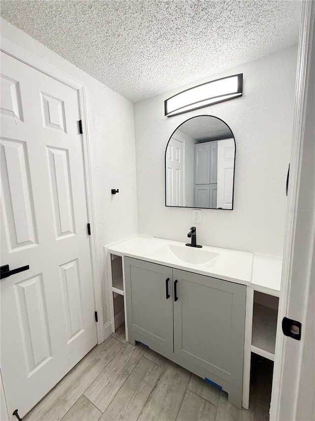 bathroom featuring vanity, hardwood / wood-style floors, and a textured ceiling