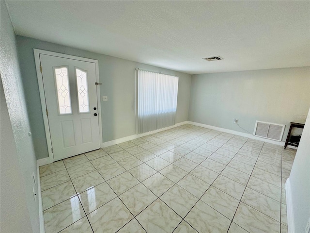 tiled foyer with plenty of natural light and a textured ceiling