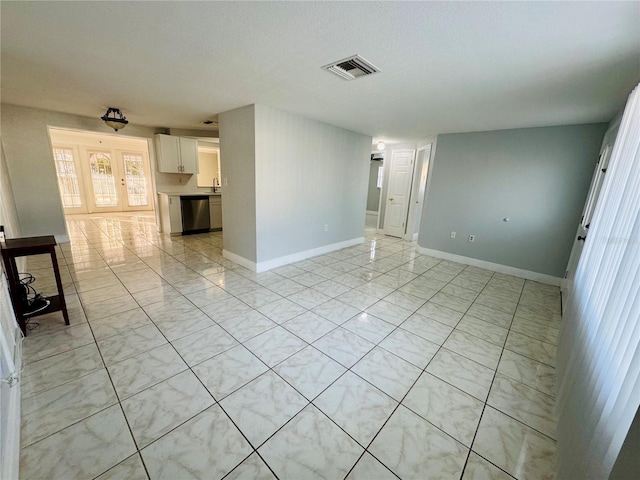 spare room featuring sink, a textured ceiling, and light tile patterned floors