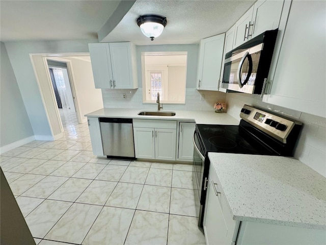 kitchen with sink, white cabinets, and appliances with stainless steel finishes