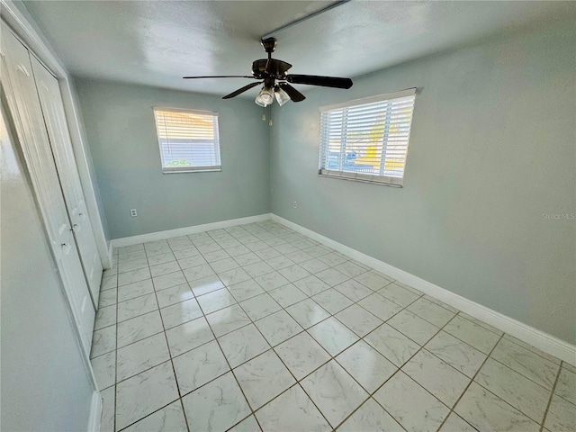 unfurnished bedroom featuring ceiling fan, a closet, and multiple windows