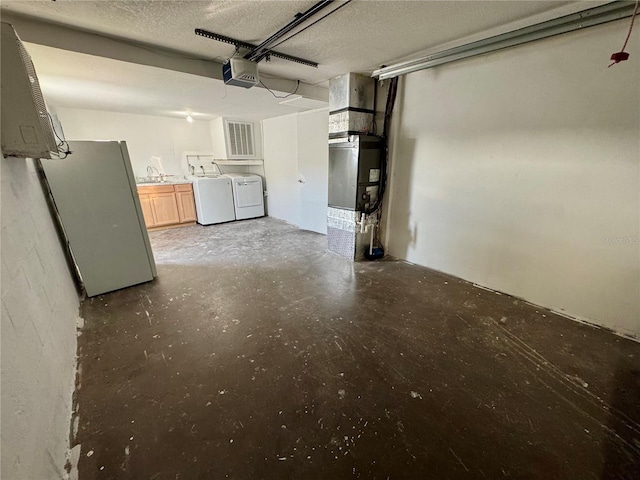 garage with sink, a garage door opener, heating unit, separate washer and dryer, and white fridge