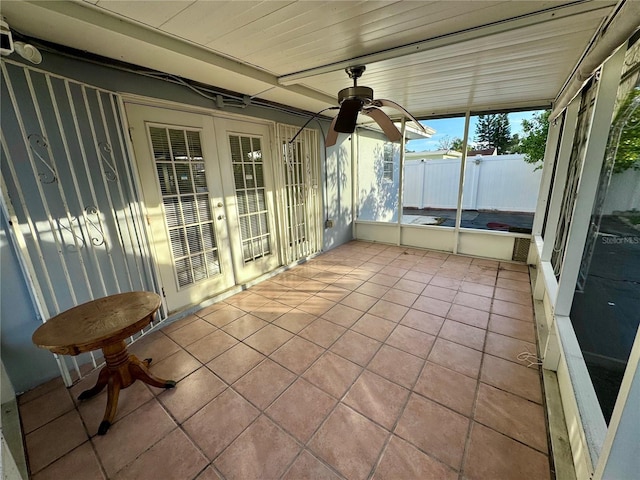 unfurnished sunroom featuring ceiling fan and french doors