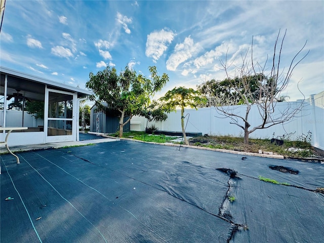 view of swimming pool featuring a sunroom and a storage shed