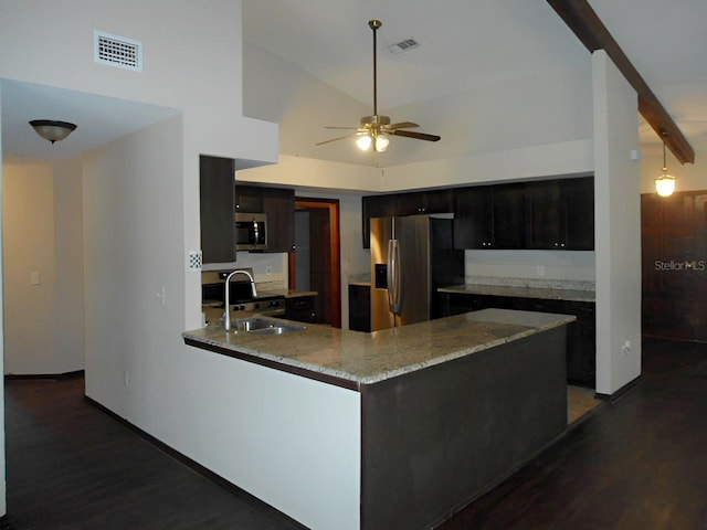 kitchen with sink, vaulted ceiling, dark hardwood / wood-style flooring, kitchen peninsula, and stainless steel appliances