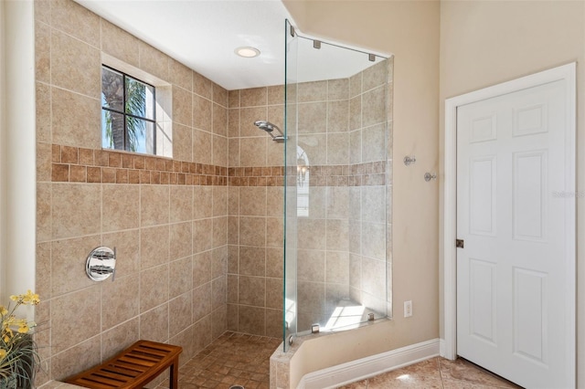 bathroom featuring tile patterned flooring and tiled shower