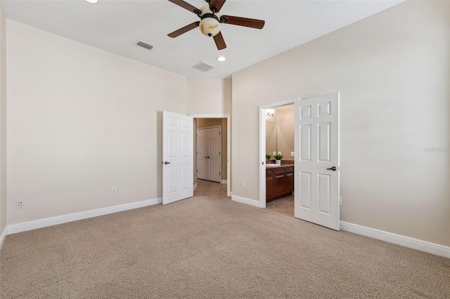 unfurnished bedroom featuring light colored carpet, ceiling fan, and ensuite bathroom